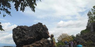 Seorang pengunjung berusaha mendorong watu goyang di obyek wisata Mangunan, Bantul DIY-foto-suwandi